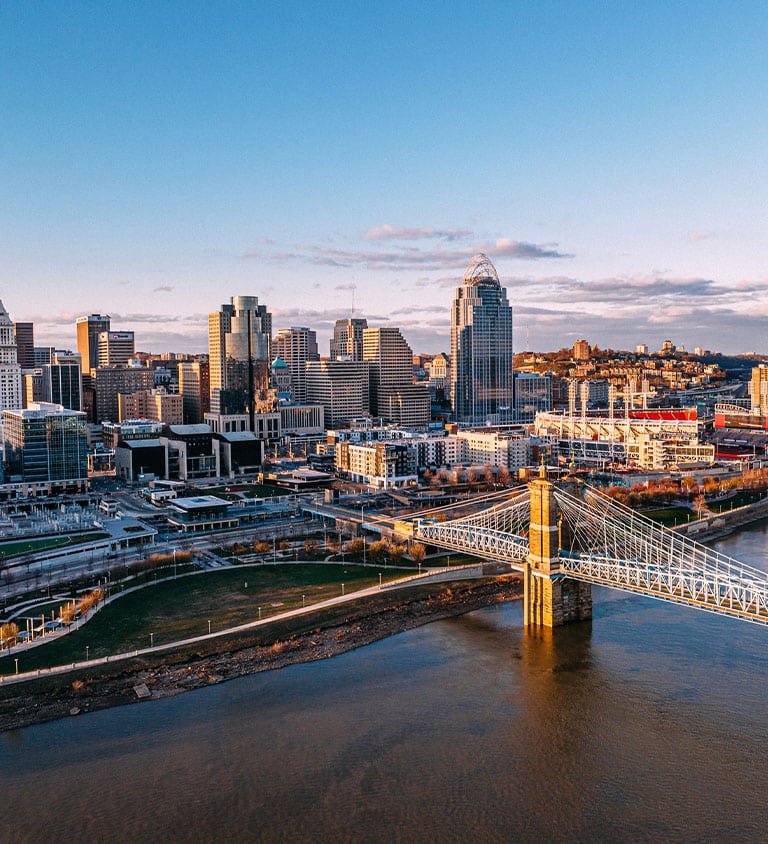 a bridge over a body of water with a city in the background